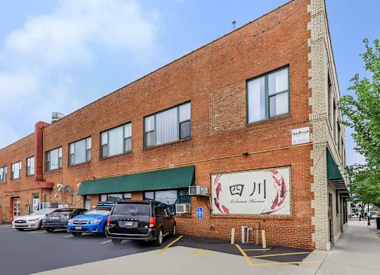 A red brick building with a green awning and a sign with Chinese characters on it.