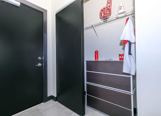 A black door is on the left and a white towel is hanging on a rack on the right.
