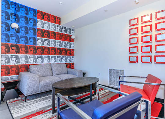 A living room with a grey couch, a red chair, and a table.