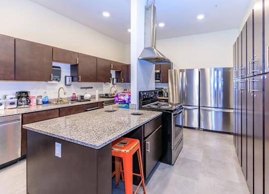 A modern kitchen with a large island and stainless steel appliances.
