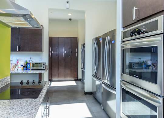 A kitchen with a stove top oven and a refrigerator.