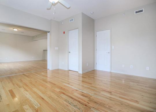 A room with wooden flooring and white walls.