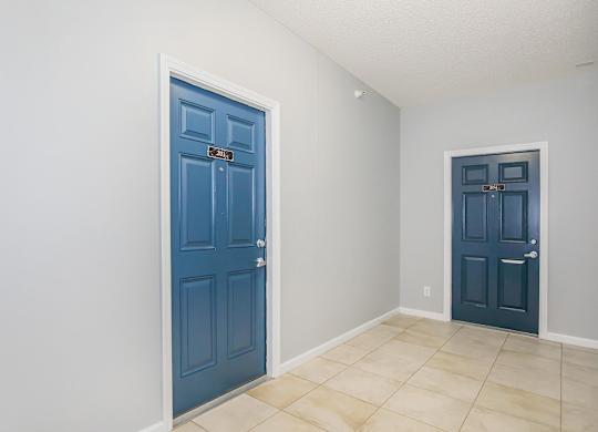A room with a blue door and a white wall.