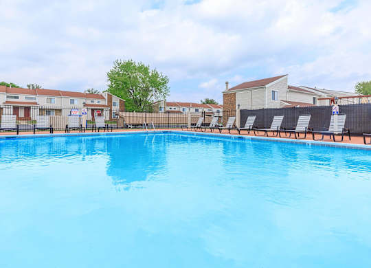 A large blue swimming pool in the middle of a residential area.