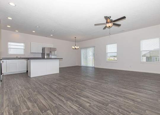 A spacious room with a ceiling fan and wooden flooring.