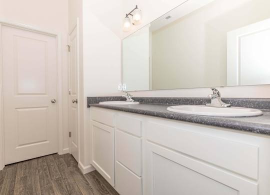 A bathroom with a white sink and a white door.