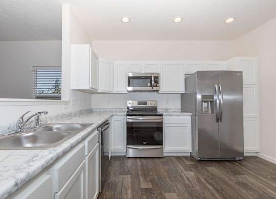 A modern kitchen with stainless steel appliances and white cabinets.