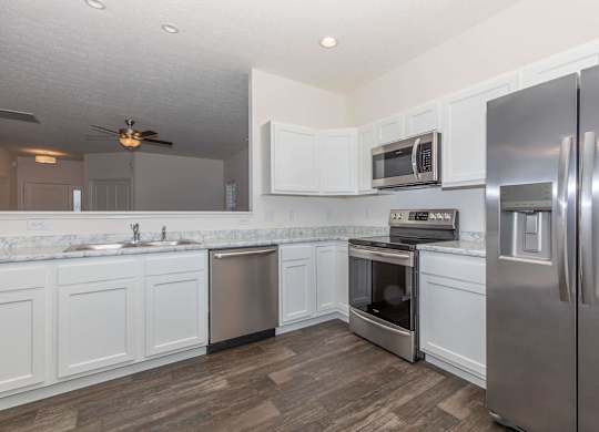 A kitchen with white cabinets and stainless steel appliances.