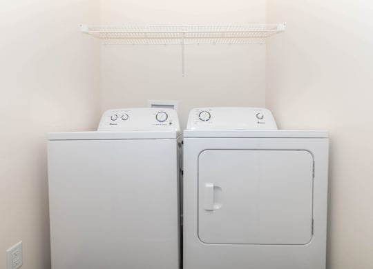 Two white washing machines in a laundry room.