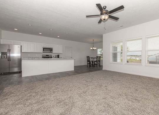 A spacious kitchen with a fan on the ceiling.