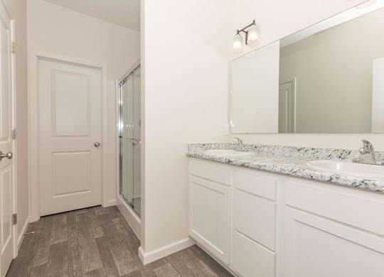 A bathroom with a marble countertop and a large mirror.