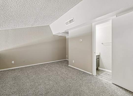 A room with a carpeted floor and a white door.