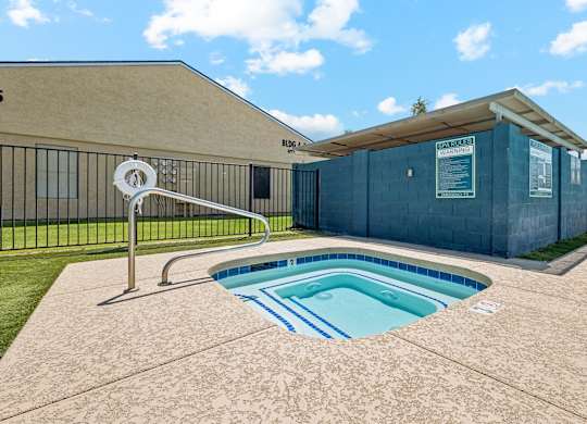A small pool with a slide in front of a building.