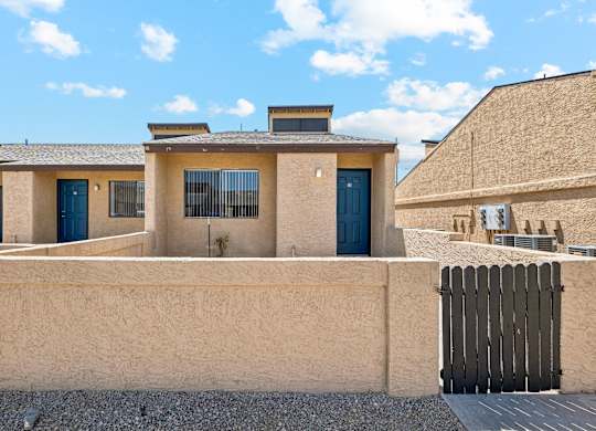 A house with a blue door and a wooden fence.