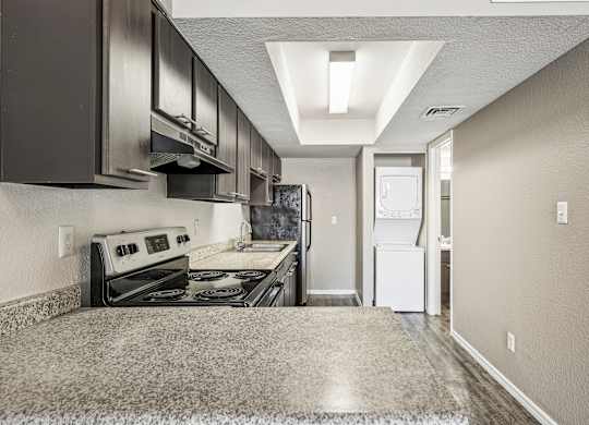 A kitchen with a stove top oven and a refrigerator.