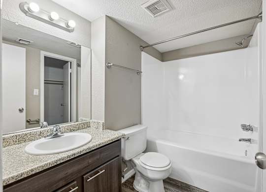 A white toilet sits next to a sink in a bathroom.