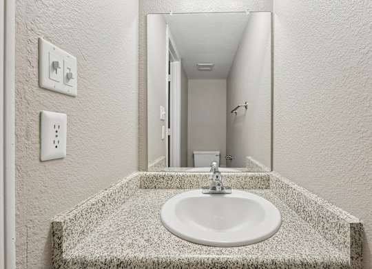 A bathroom with a sink and mirror.