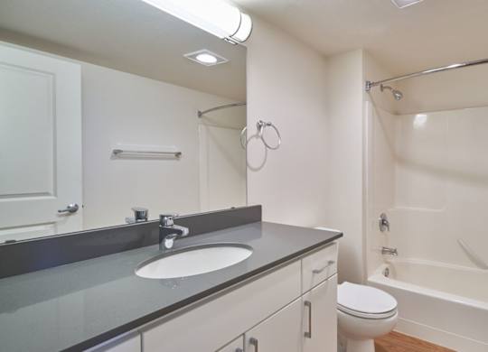 A white bathroom with a sink, toilet, and bathtub.