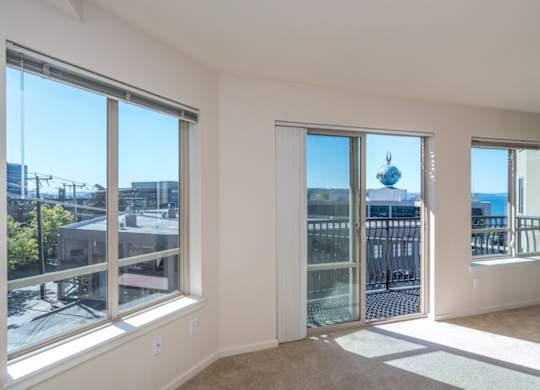A room with a view of the city through large windows.