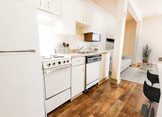 a kitchen with white appliances and a wood floor at Zindorf, Seattle, Washington