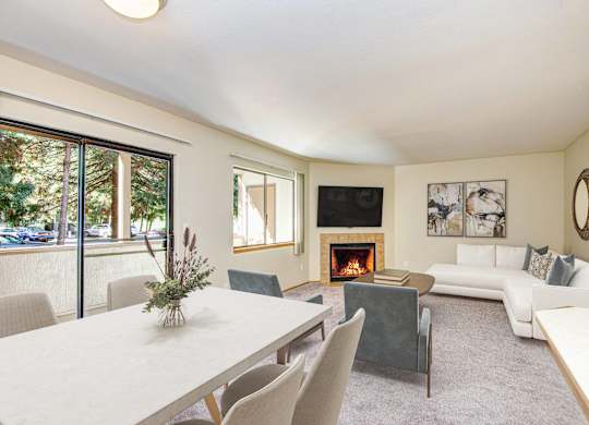 A living room with a fireplace and a dining table. at Autumn Village, Milton, WA, 98354