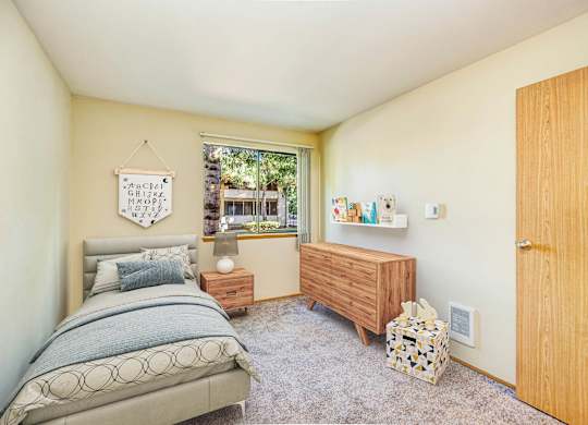 A bedroom with a bed, nightstand, and a window. at Autumn Village, Washington, 98354