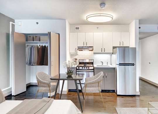 A modern kitchen with a table and chairs in the middle.