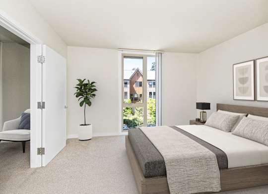 A bedroom with a large bed and a potted plant.