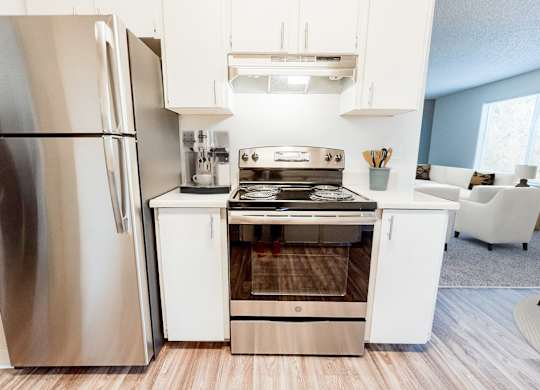 A modern kitchen with a stainless steel refrigerator and a white island with a stove.