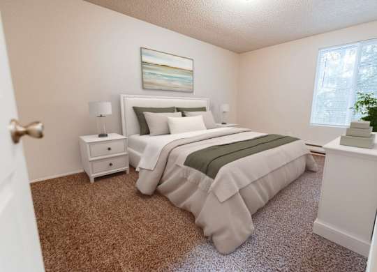 A bedroom with a large bed and a nightstand with a lamp.