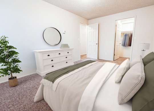 A bedroom with a bed, dresser, and mirror.