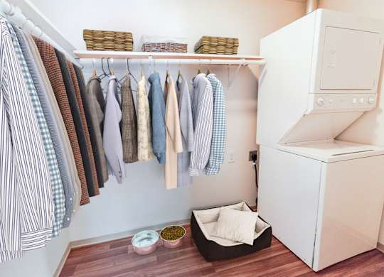 A laundry room with clothes hanging and a washing machine.