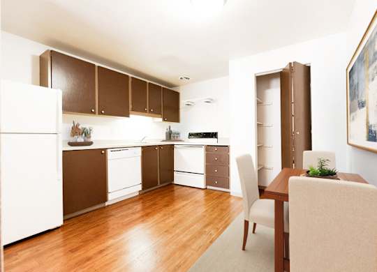 A kitchen with brown cabinets and a white fridge.