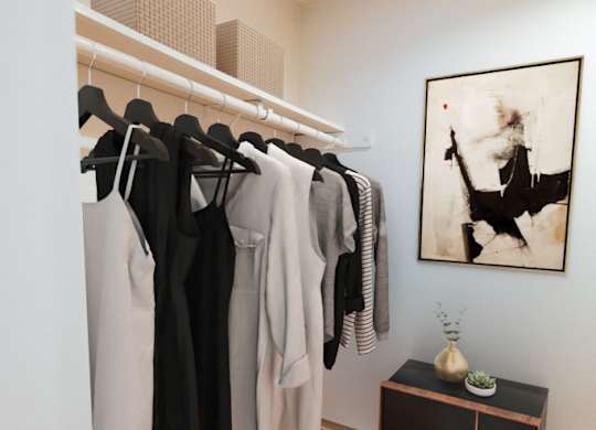 A room with a row of clothes hanging up on a rail and a picture on the wall.