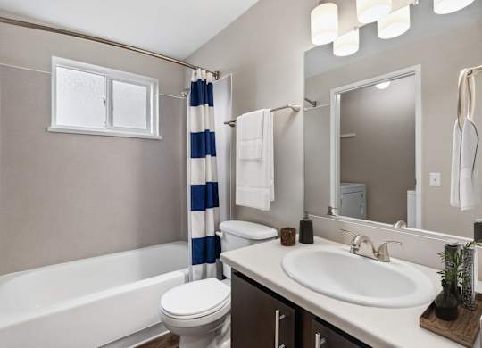 A bathroom with a white tub, toilet, and sink.