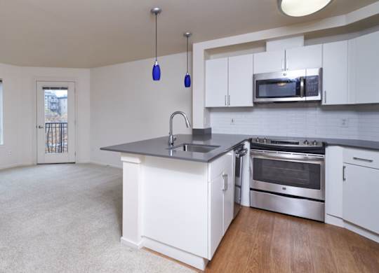 A kitchen with white cabinets and a large island.