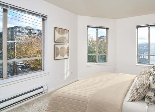 A bedroom with a large bed and a view of the city.