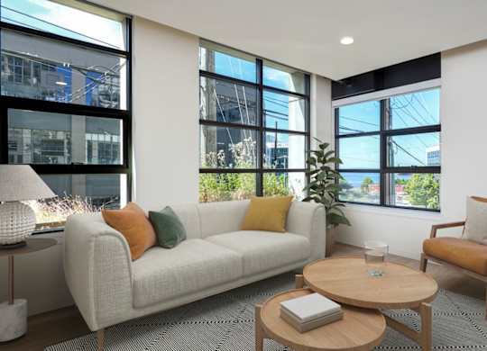 A living room with a white couch, a wooden coffee table, and a chair.
