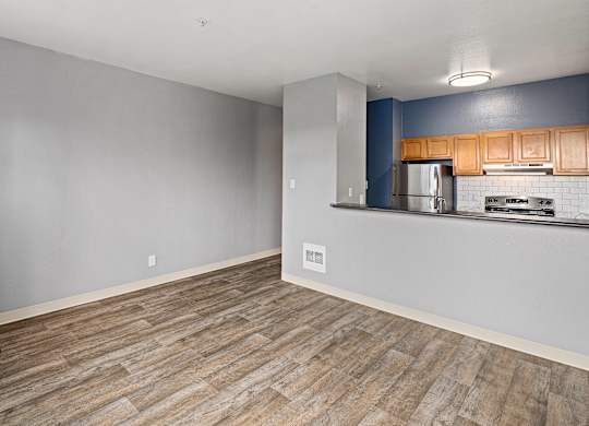 A kitchen with wooden cabinets and a stainless steel refrigerator.