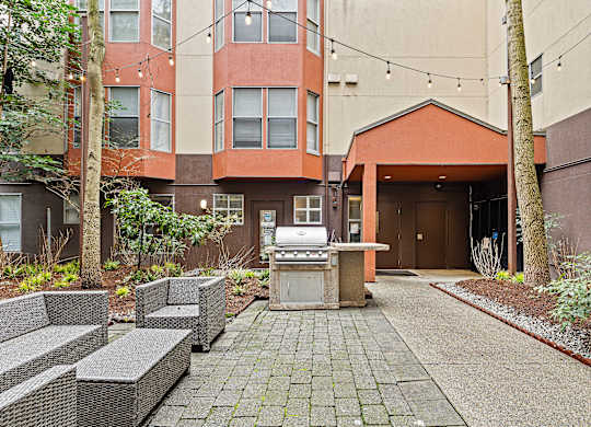 A patio area with a table and chairs in front of a building.