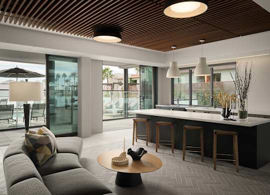 A modern living room with a grey sofa and a wooden ceiling.