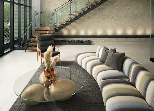 A modern interior with a glass table and striped sofas.