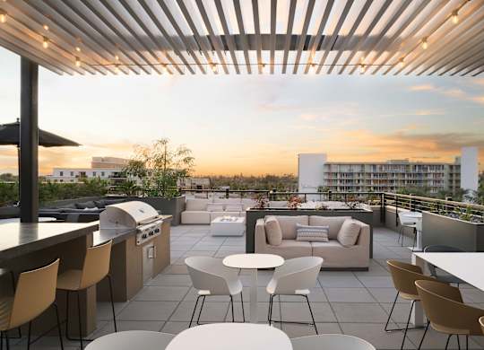 A rooftop patio with a bar and seating area.