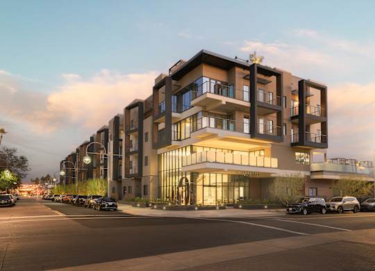A modern apartment building with cars parked in front.