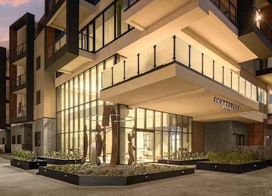 A modern building with a sculpture in front of it.