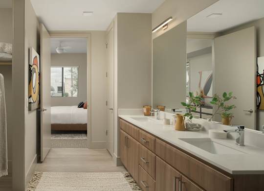 A bathroom with a white counter top and a mirror above it.
