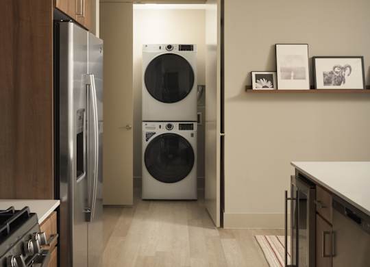 A modern kitchen with a washer and dryer built into the wall.