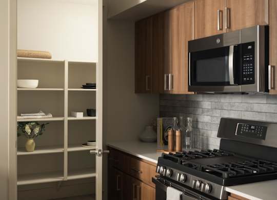 A modern kitchen with a black stove and wooden cabinets.