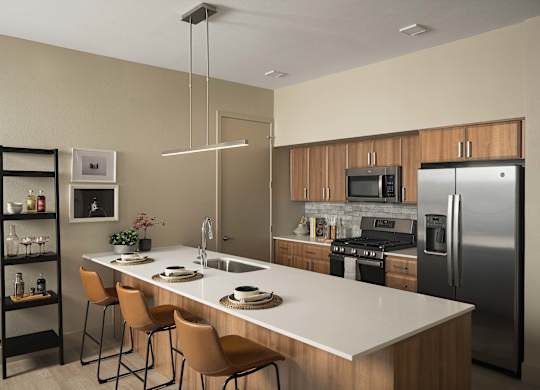 A modern kitchen with a white countertop and stainless steel appliances.
