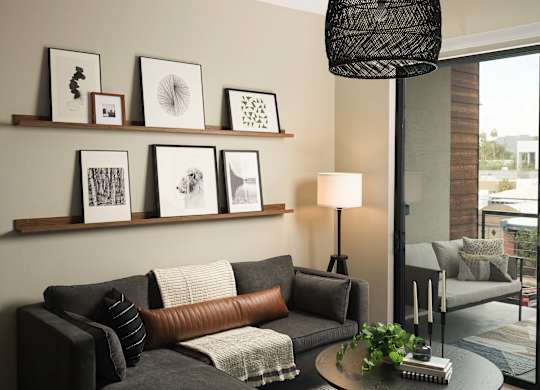 A living room with a grey couch, a coffee table, and a lamp.
